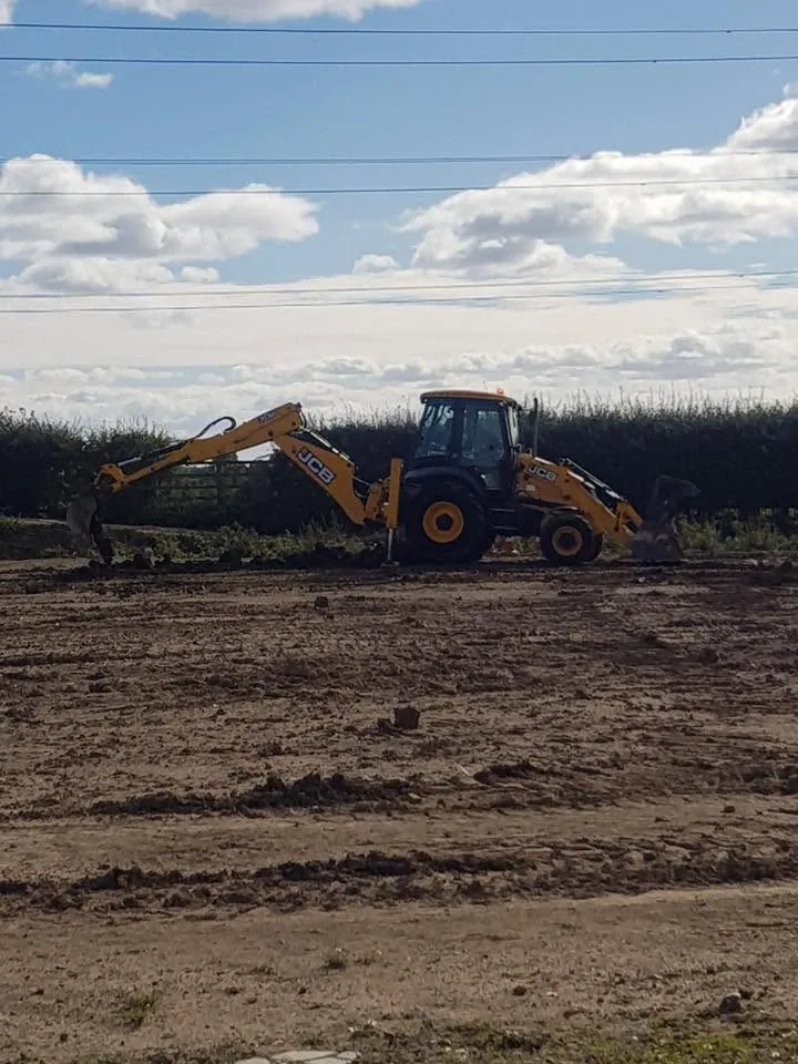 JCB 180-degree backhoe excavator on a training ground