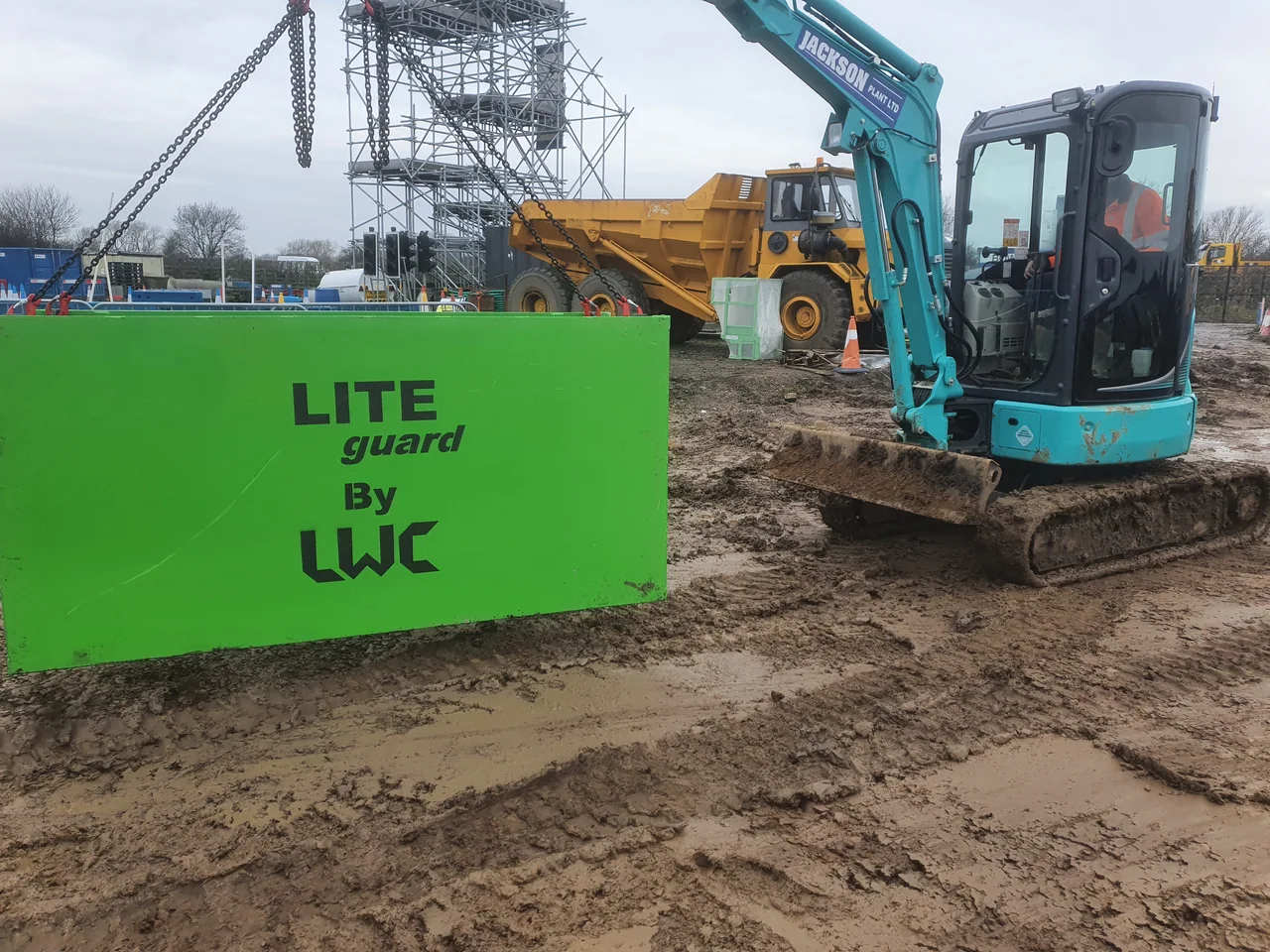 Mini excavator operating beside utility excavation shoring equipment